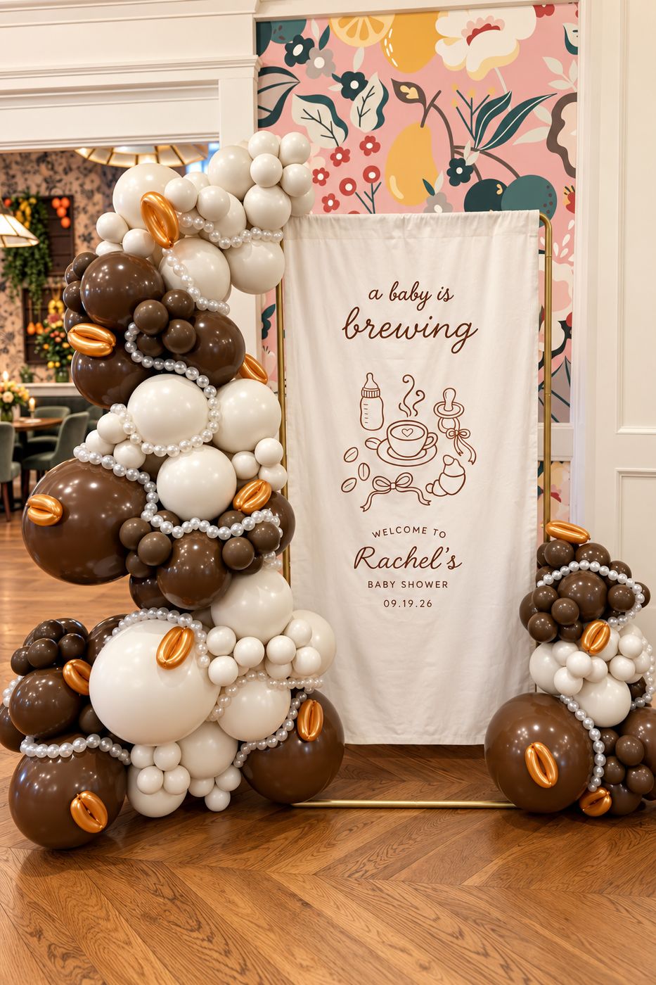 Brown, cream and pearl balloon garland with coffee-bean accents around a baby shower welcome sign