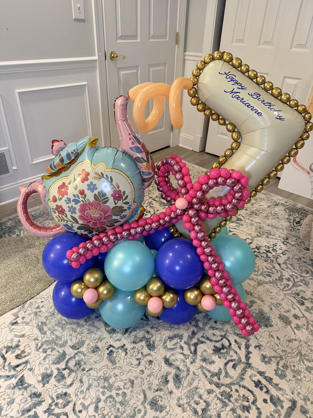 Birthday balloon bouquet with a floral teapot foil, gold-beaded message balloon and pink balloon bow